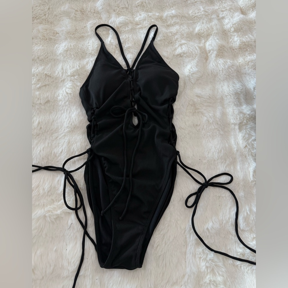 Black one piece bathing suit with adjustable strings. Medium